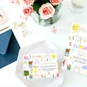 May include: A colorful invitation for a baby's second birthday party. The invitation features a rainbow, a sun, a teddy bear, and the text "A little sunshine is turning two".