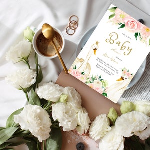 May include: A white and gold baby shower invitation with a swan design and pink floral accents. The text reads "Join us for a Baby Shower Honoring Abion Gleas. Saturday, June 11th at two o'clock 116 Rossini Via | Los Angeles, CA Hosted by Annie and Kate. Regrets to 701-222-4297"