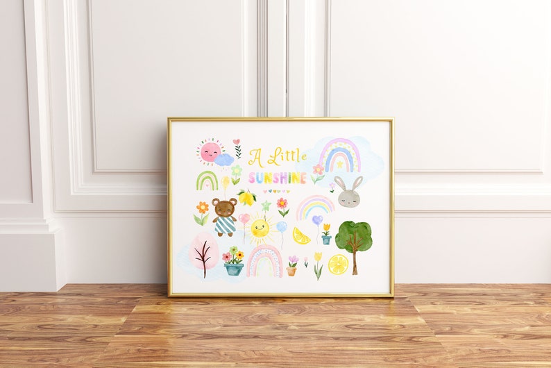 May include: A gold framed print with a white background and colorful illustrations of a bear, a bunny, rainbows, lemons, flowers, and a sun. The text "A Little Sunshine" is in the center of the print.