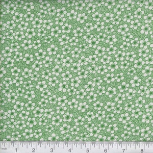 May include: Green fabric with a white floral pattern. The fabric is covered in small white flowers with a green outline.