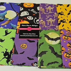May include: A set of 8 Halloween fabric squares featuring various spooky designs, including ghosts, bats, pumpkins, witches, and skeletons. The fabrics are in a variety of colors, including orange, purple, green, yellow, and blue.