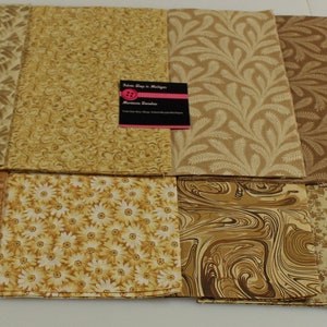 May include: A collection of ten fabric squares in various shades of brown and beige with different patterns, including floral, geometric, and abstract designs. The fabric squares are arranged in two rows of five.