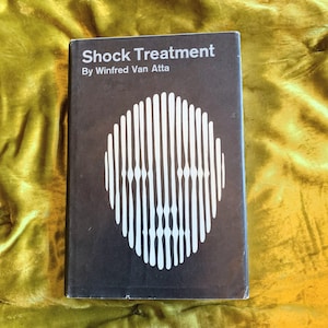 May include: A black book with the title "Shock Treatment" by Winfred Van Atta. The cover features a white graphic of a circle with vertical lines radiating outward.