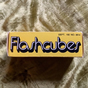 May include: A yellow box with black text that reads "Flashcubes" and the text "DEPT. 192 NO. 0014" in the top right corner.