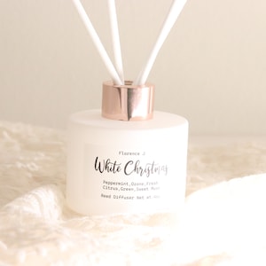 Può includere: Bottiglia di vetro bianco opaco con tappo color oro rosa e bastoncini diffusori. L'etichetta riporta "Florence White Christmas" e elenca le note olfattive: Menta piperita, Ozono, Agrumi freschi, Verde, Muschio dolce. Diffusore a bastoncini Peso netto 100ml.