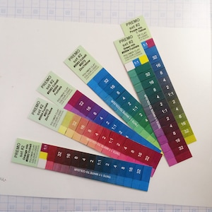 May include: A set of Premo Polymer Clay color charts, showing different shades of orange, fuchsia, cobalt, green, purple, and yellow. Each chart has a color name and number, and shows the color mixed with white in different ratios.