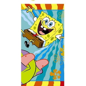 May include: A rectangular beach towel featuring the animated character SpongeBob SquarePants. The towel has a blue background with SpongeBob in the center, smiling and holding a brown briefcase. The bottom of the towel shows a pink starfish hand.