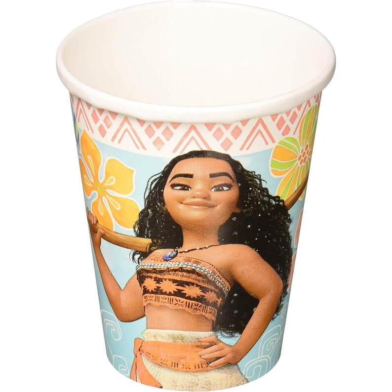 May include: A disposable paper cup featuring a light blue background with a printed illustration of a character with long dark curly hair, wearing an orange patterned top and skirt, surrounded by yellow and green tropical flower graphics.