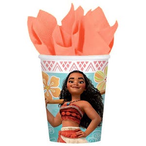 May include: A paper cup featuring a graphic of a character with long dark curly hair, wearing a red patterned top and skirt, set against a light blue background with yellow flowers and a pink geometric border, filled with peach-colored tissue paper.
