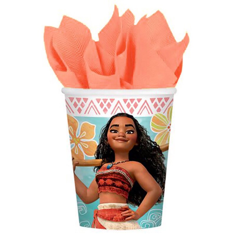 May include: A paper cup featuring a graphic of a character with long dark curly hair, wearing a red patterned top and skirt, set against a light blue background with yellow flowers and a pink geometric border, filled with peach-colored tissue paper.