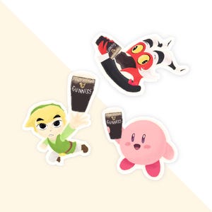 May include: A collection of colorful stickers featuring cartoon characters and Guinness beer glasses. One sticker depicts a red and black creature holding a Guinness bottle. Another shows a character in green clothing. A pink character holds a Guinness glass.