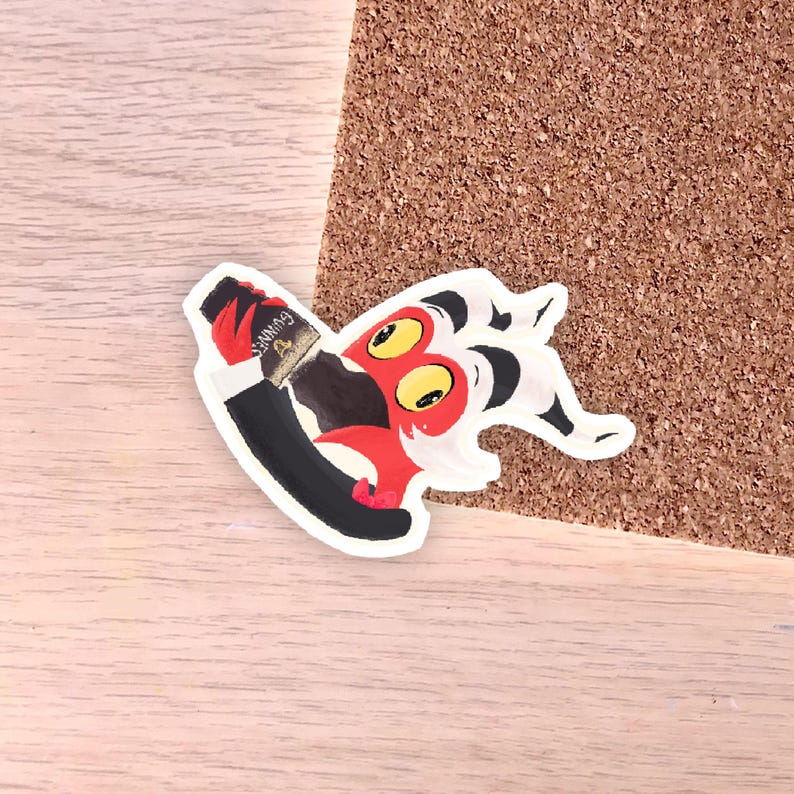 May include: A colorful sticker featuring a cartoon character with red, black, and white details. The character is holding a bottle of Guinness. The sticker is on a wooden surface.