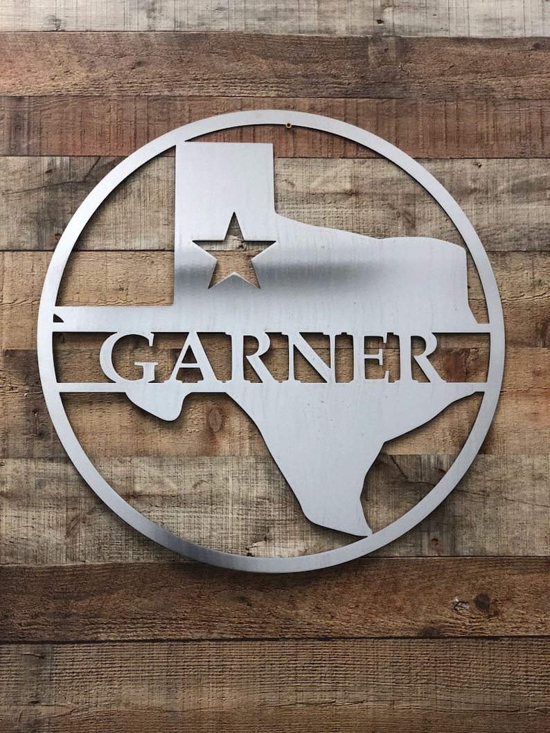 May include: A silver metal Texas state outline with a star in the center and the name "GARNER" across the bottom. The outline is in a circle.