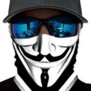 May include: A black and white face mask with a stylized image of the Guy Fawkes mask. The mask has a black and white design with a white smile and a black tie. The mask is worn by a person wearing a black baseball cap and blue sunglasses.