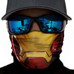 May include: A black baseball cap with a red and yellow face mask featuring a superhero design. The face mask has a yellow and red design with a metallic sheen.