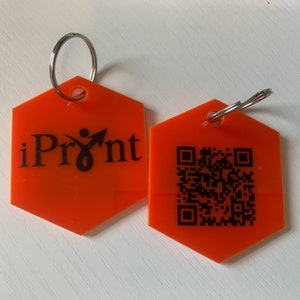 May include: Two orange hexagonal keychains with a silver ring. One keychain has the text "iPrint" and a stylized person icon. The other keychain has a black and white QR code.