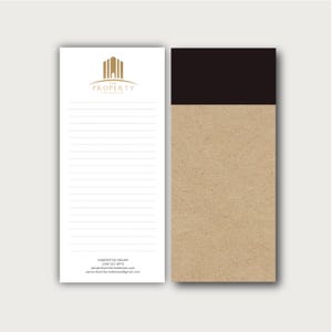 May include: Two rectangular notepads. The left notepad is white with horizontal lines, a gold building logo, and text reading THE PROPERTY, SAMANTHA MILLER, (234) 567-8910, samanthamillerrealestate.com, and samanthamillerrealestate@gmail.com. The right is brown kraft paper.