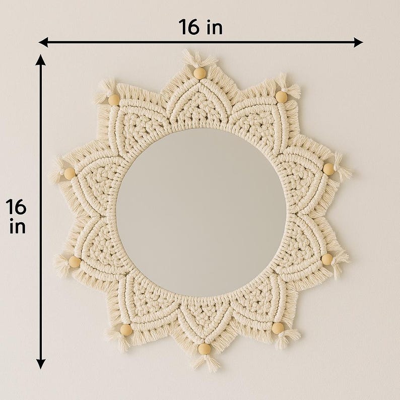May include: A round mirror with a cream-colored macrame sunburst design. The mirror is 16 inches in diameter and features wooden bead accents.