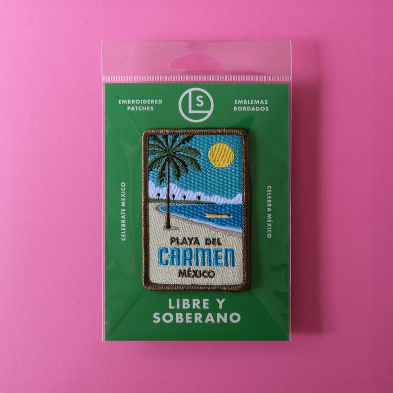 May include: A green and brown embroidered patch with a beach scene. The patch features a palm tree, a blue ocean, and a yellow sun. The text "Playa del Carmen, Mexico" is embroidered on the patch.