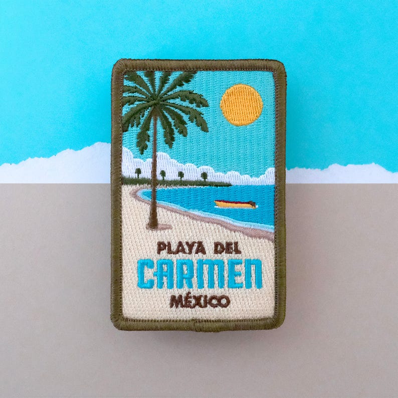 May include: A green, brown, and blue embroidered patch with a palm tree, sun, and beach scene. The text "Playa del Carmen, Mexico" is embroidered on the patch.