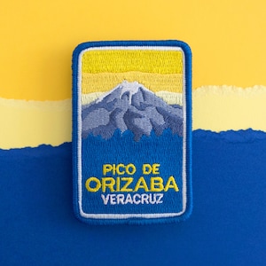 May include: A blue and yellow embroidered patch with a mountain scene and the text "Pico de Orizaba Veracruz".