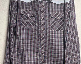 May include: A long-sleeved plaid shirt with a blue, red, and white pattern. The shirt has a yoke in a light blue color and two chest pockets with button closures.