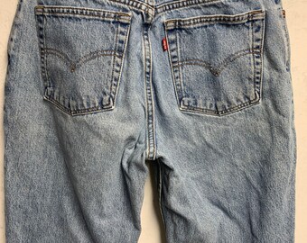 May include: Light blue denim jeans with classic five-pocket design. Features include a red Levi's tag on the back pocket and a leather Levi Strauss & Co. patch. The jeans are hung on a white hanger.