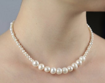 A small pearl necklace with an elegant design. Natural river pearls. Eternal classics for any look. Necklace for wedding.