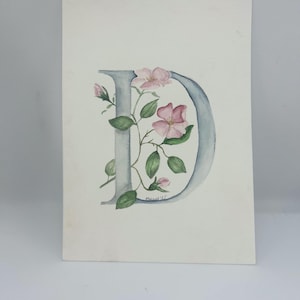 Letra D original en acuarela entrelazada con rosa canina