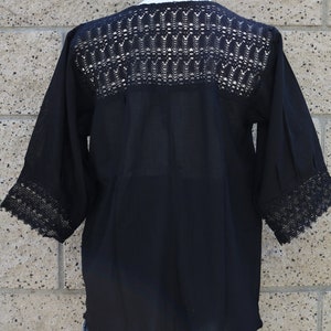 May include: Black crochet top with a lace trim around the neckline and sleeves. The top is made of a lightweight fabric and has a relaxed fit.