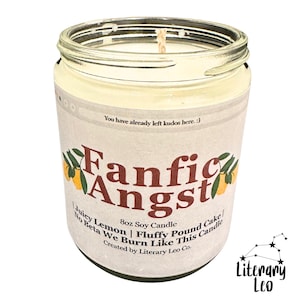 May include: A clear glass jar candle with a cream-colored label. The label reads "Fanfic Angst" with lemon illustrations. The candle is 8oz and scented with juicy lemon and fluffy pound cake. Text at the bottom says "Created by Literary Leo Co."