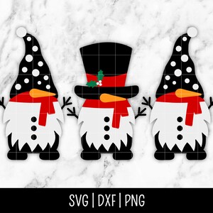 May include: Three black and white snowman gnomes with red hats and scarves. The middle gnome is wearing a black top hat.