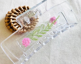 Pince florale transparente avec fleurs roses et verdure, vraies fleurs conservées dans de la résine