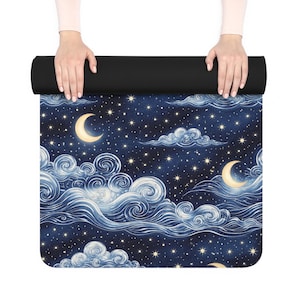 May include: A yoga mat with a night sky design. The mat has a dark blue background with white clouds, crescent moons, and stars. The top of the mat is black.