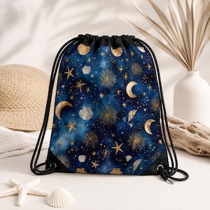 Peut inclure: Un sac à dos à cordon avec un fond céleste bleu profond orné de croissants de lune dorés, d'étoiles variées, d'éclats solaires rayonnants et de coquillages blancs dispersés. Le sac possède des cordons noirs et des renforts d'angle noirs.