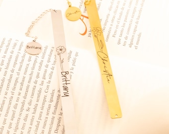 May include: Two personalized bookmarks are displayed, one silver and one gold. The silver bookmark has a chain and a round charm with the name "Brittany." The gold bookmark has the name "Christie" and a floral design.