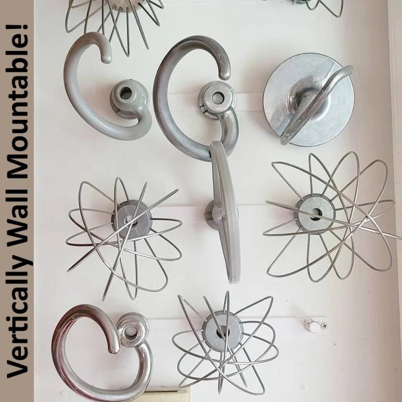 Op de afbeelding: Een verzameling vintage keuken-gardes en wandgrepen in verschillende ontwerpen. De gardes hebben draad lussen die uitstralen vanuit een centrale naaf. De handgrepen zijn gebogen en grijs. De tekst "Vertically Wall Mountable!" is zichtbaar links.