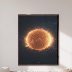 以下が含まれることがあります： 暗い背景に輝く太陽を描いた額入りのアートプリント。ベージュのセクショナルソファとクッションの上に飾られています。部屋には窓、小さなサイドテーブル、木製のフローリングがあります。アートワークはリビングスペースの焦点となっています。