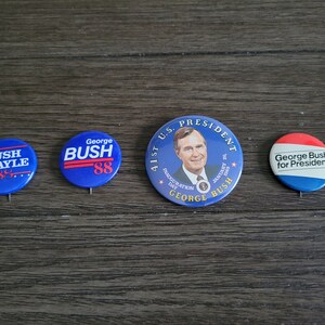 May include: Four blue and red political campaign buttons featuring George Bush. The buttons feature the text "Bush Quayle", "George Bush 88", "41st U.S. President Inauguration Day January 20, 1989 George Bush", and "George Bush for President."