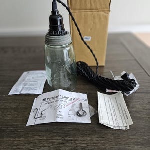 May include: A DIY pendant lamp kit with a clear glass jar, black electrical cord, and black socket. The kit includes two hanging hooks and two plastic clamps. The instructions say "Pendant Lamp Assemb included in your kit: x2 hanging hooks, x2 plastic clamps".