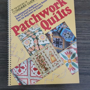 May include: A yellow book with the title "Patchwork Quilts" and a spiral binding. The cover features images of colorful patchwork quilts and quilting instructions.
