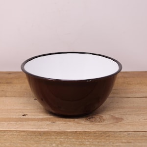 May include: A brown enamel mixing bowl with a white interior. The bowl is round and has a smooth, glossy finish.