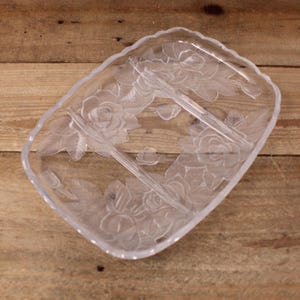 May include: A clear glass serving dish with three sections. The dish is decorated with an etched floral design of roses and leaves.