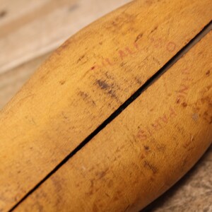 May include: A wooden shoe stretcher with a split design. The stretcher has red writing on it that says "FULL LAST" and "SUPER QUALITY".