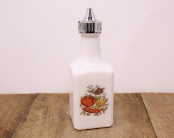 May include: White ceramic bottle with a silver top and a painted design of vegetables, including a tomato, carrot, and mushroom.