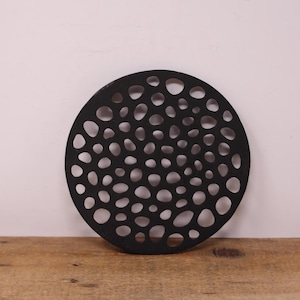 Dessous de plat rond vintage en fonte noire avec un design découpé