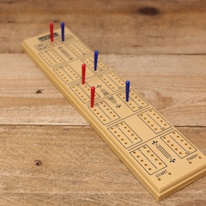 May include: A wooden game board with a yellow surface and black markings. The board has a "START" and "FINISH" label. There are red and blue pegs on the board.