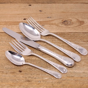 May include: Silverware set including two forks, two spoons, and a knife, arranged diagonally on a wooden surface. The utensils have a shiny finish and decorative detailing on the handles. The set is ideal for formal dining.