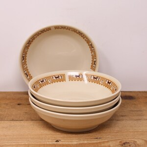 May include: Four white ceramic bowls with a brown and tan geometric pattern around the rim. The bowls are stacked on top of each other.