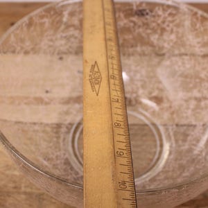 May include: A clear glass bowl with a textured surface. The bowl is approximately 25 cm in diameter.